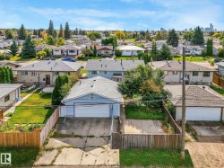 Residential property with a single-story structure, a paved driveway, a two-car attached garage, and a fenced backyard - 