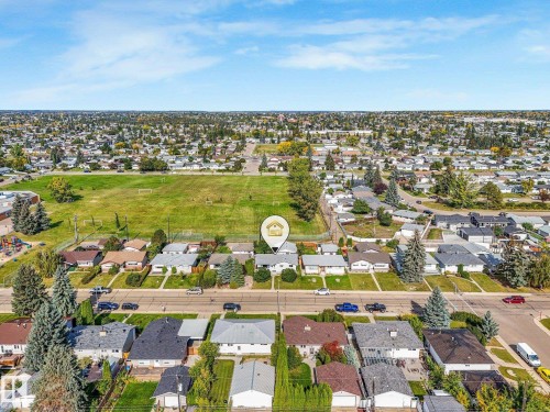 Aerial perspective showcasing a residential neighborhood with a large green space - 7520 130 Avenue Nw, Edmonton, AB 
