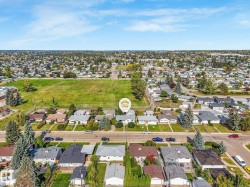 Aerial perspective showcasing a residential neighborhood with a large green space - 