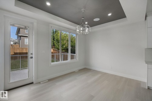 Recessed ceiling lighting, tray ceiling design, contemporary chandelier, large windows, and wood-finish flooring - 3699 Hummingbird Way Nw, Edmonton, AB 