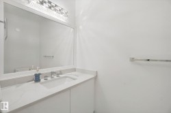 Integrated vanity with a rectangular undermount sink, a chrome two-handle faucet, and a large wall-mounted mirror - 