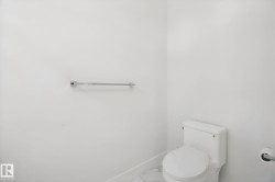 White ceramic toilet with a matching toilet paper holder and a chrome towel bar - 