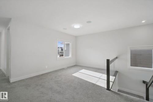 Carpeted flooring with a modern glass railing, recessed lighting, and a flush mount ceiling light - 3699 Hummingbird Way Nw, Edmonton, AB 