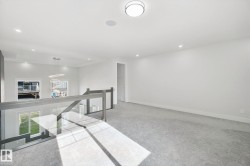 Recessed lighting, wall-to-wall carpeting, contemporary glass railing, modern semi-flush mount light fixture, and built-in ceiling speaker - 