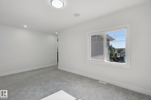 Recessed lighting, large window with multi-pane grid, carpeted flooring, and a flush mount ceiling light - 3699 Hummingbird Way Nw, Edmonton, AB 