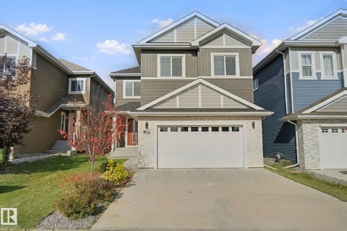 Two-story home with a two-car garage, stone and siding exterior, and a concrete driveway - 3699 Hummingbird Way Nw, Edmonton, AB 