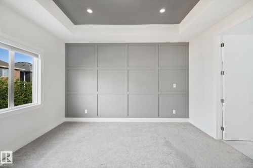 Recessed lighting, tray ceiling, accent wall with paneling, window, and wall-to-wall carpeting - 3699 Hummingbird Way Nw, Edmonton, AB 