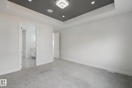 Recessed ceiling with an accent color, contemporary chandelier, and integrated speakers - 3699 Hummingbird Way Nw, Edmonton, AB 