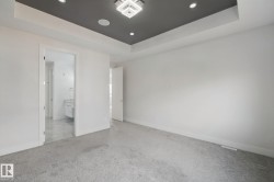 Recessed ceiling with an accent color, contemporary chandelier, and integrated speakers - 