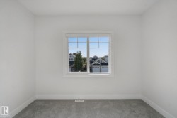White painted walls, gray carpeting, and a white framed window - 