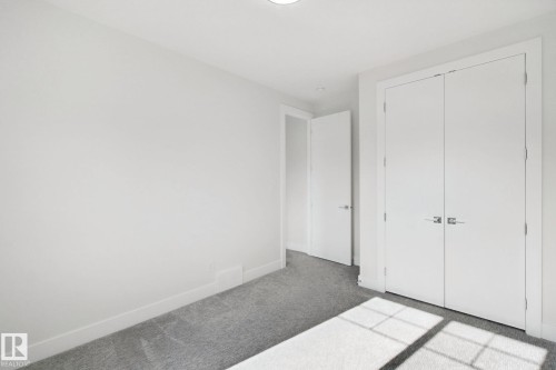 Neutral wall color, grey carpet flooring, white trim, recessed lighting, and a white interior door - 3699 Hummingbird Way Nw, Edmonton, AB 