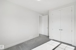 Neutral wall color, grey carpet flooring, white trim, recessed lighting, and a white interior door - 