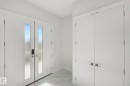 Double entry doors with vertical frosted glass panels and modern hardware - 3699 Hummingbird Way Nw, Edmonton, AB 