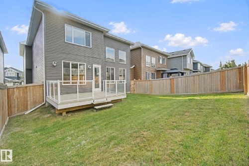 Spacious backyard featuring a sloped lawn and wood fencing - 3699 Hummingbird Way Nw, Edmonton, AB 