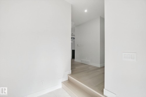 Recessed lighting illuminates the wood-finish flooring and white walls - 3699 Hummingbird Way Nw, Edmonton, AB 