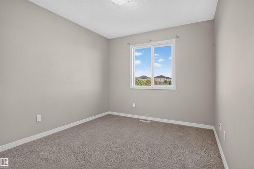 Neutral-toned walls complement the textured carpeting - 2145 28 Street Nw, Edmonton, AB 