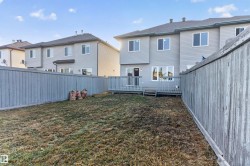 Rear exterior featuring a wood deck with railings, sliding glass patio door, and multiple windows - 