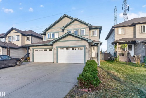 Two-story home with light-colored siding, a dark roof, and a two-car garage - 2145 28 Street Nw, Edmonton, AB 