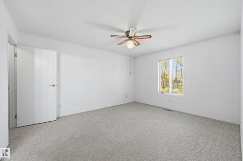 Room featuring neutral carpeting, a ceiling fan with light fixture, and a single-pane window - #19 10 Grange Dr, St. Albert, AB 