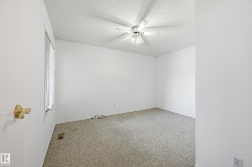 Neutral-toned carpeted flooring, white walls, and a ceiling-mounted light fixture with a fan - #19 10 Grange Dr, St. Albert, AB 