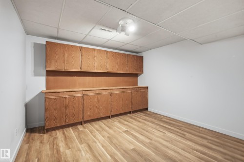Wood-finish flooring, built-in wooden cabinetry, pegboard wall organizing system, and a drop ceiling - #19 10 Grange Dr, St. Albert, AB 