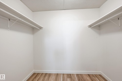 Walk-in storage space featuring wood-finish flooring and dual tiers of white shelving - #19 10 Grange Dr, St. Albert, AB 