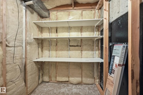 Storage area featuring exposed timber wall framing, fiberglass insulation, and three tiers of white adjustable wall-mounted shelving - #19 10 Grange Dr, St. Albert, AB 