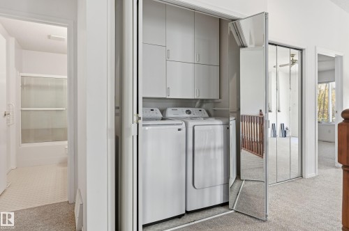Laundry closet featuring overhead built-in cabinetry and mirrored bi-fold doors - #19 10 Grange Dr, St. Albert, AB 