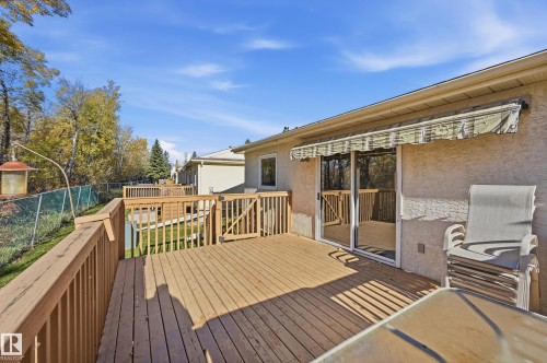 Elevated wood deck featuring vertical balusters, a retractable awning, and sliding glass door access - #19 10 Grange Dr, St. Albert, AB 