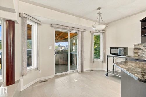 Tiled flooring, multiple windows, and a sliding glass door - 771 Johns Road Nw, Edmonton, AB 