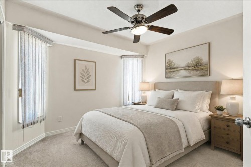 Recessed ceiling fan with integrated lighting, window with vertical blinds, neutral wall paint, light-toned carpet flooring, and a fabric-upholstered headboard - 771 Johns Road Nw, Edmonton, AB 