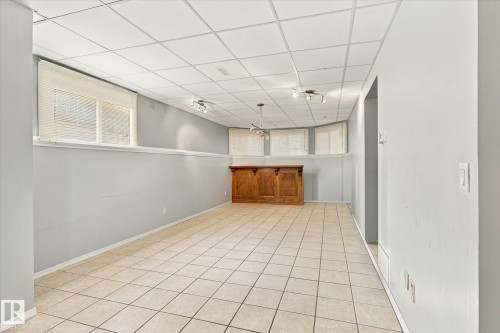 Tile flooring, drop ceiling with recessed lighting, integrated wooden bar, and multiple windows - 771 Johns Road Nw, Edmonton, AB 