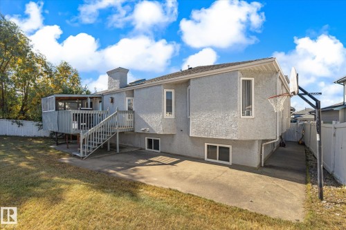 Rear exterior featuring a screened-in deck, a built-in outdoor basketball hoop, a concrete patio, and a fenced yard - 771 Johns Road Nw, Edmonton, AB 