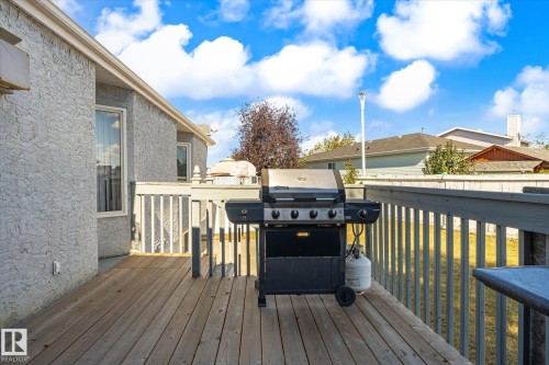 Wood-finish deck with a painted wood railing and textured exterior siding - 771 Johns Road Nw, Edmonton, AB 