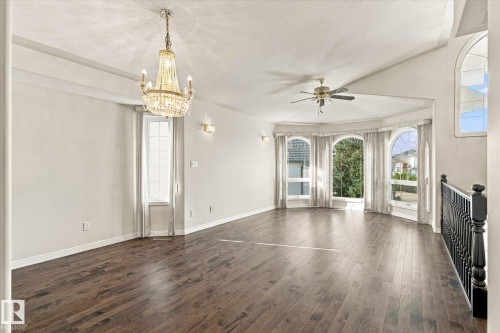 Vaulted ceiling, wood-finish flooring, arched windows, decorative chandelier, and a ceiling fan with integrated lighting - 771 Johns Road Nw, Edmonton, AB 
