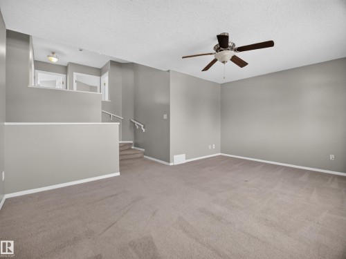 Spacious room with neutral carpeting and light gray wall paint - 14 Wells Court, Leduc, AB 