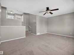 Spacious room with neutral carpeting and light gray wall paint - 