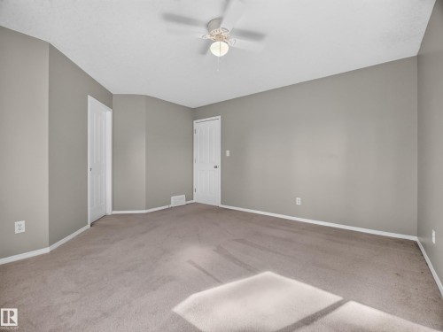 Spacious room with neutral wall tones and carpeted flooring - 14 Wells Court, Leduc, AB 