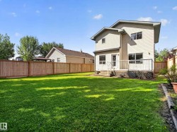 Expansive lawn with a full privacy fence, elevated wood deck, and a wood lattice skirt - 