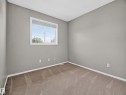 Carpeted flooring, neutral wall color, white trim, and a window with white casing - 14 Wells Court, Leduc, AB 