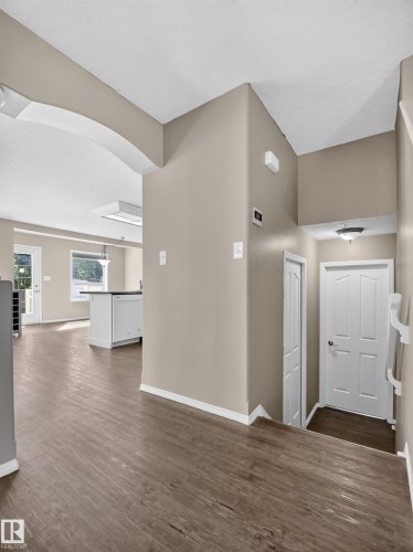 Wood-finish flooring throughout, neutral paint finishes, white trim, and white doors - 14 Wells Court, Leduc, AB 