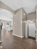 Wood-finish flooring throughout, neutral paint finishes, white trim, and white doors - 