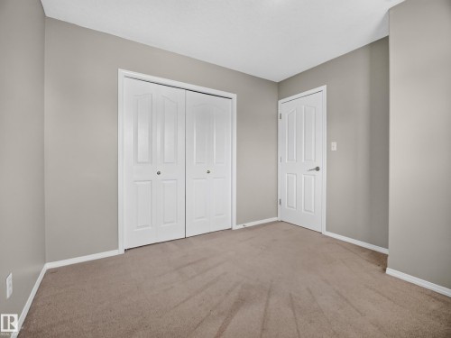 Neutral tone wall paint, white trim, paneled interior doors, and carpet flooring - 14 Wells Court, Leduc, AB 