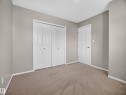 Neutral tone wall paint, white trim, paneled interior doors, and carpet flooring - 14 Wells Court, Leduc, AB 
