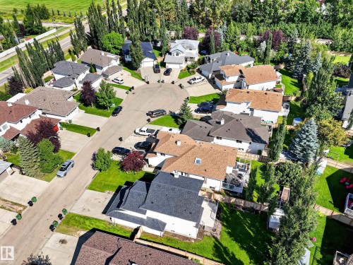 Residential properties featuring various roof styles, mature trees, and landscaped yards - 14 Wells Court, Leduc, AB 