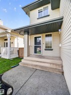 Siding exterior with a covered porch entry featuring a column, concrete steps, and a concrete pathway - 