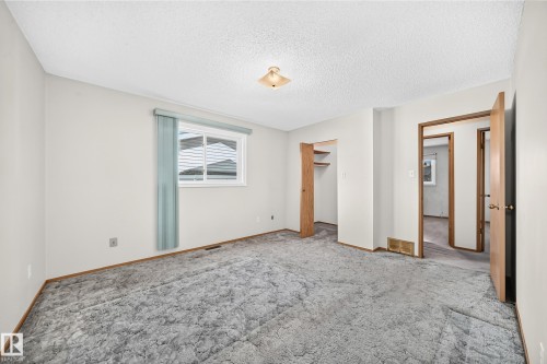 Carpeted flooring with painted walls, a built-in closet, and a window with blinds - 14519 32 Street Nw, Edmonton, AB 