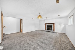 Spacious living room featuring neutral carpet flooring, white walls, and recessed lighting - 