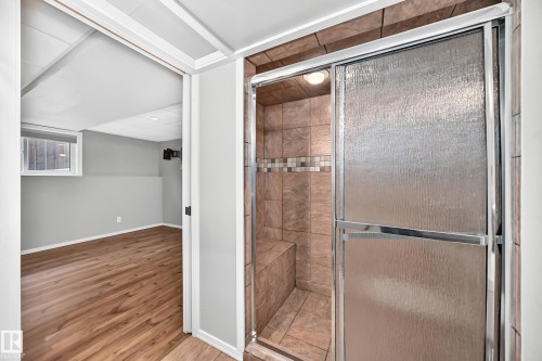 Tiled shower with sliding glass doors and a built-in bench - 14519 32 Street Nw, Edmonton, AB 