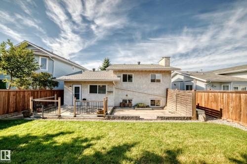Expansive backyard featuring a manicured lawn, a multi-level patio, and a privacy fence - 14519 32 Street Nw, Edmonton, AB 
